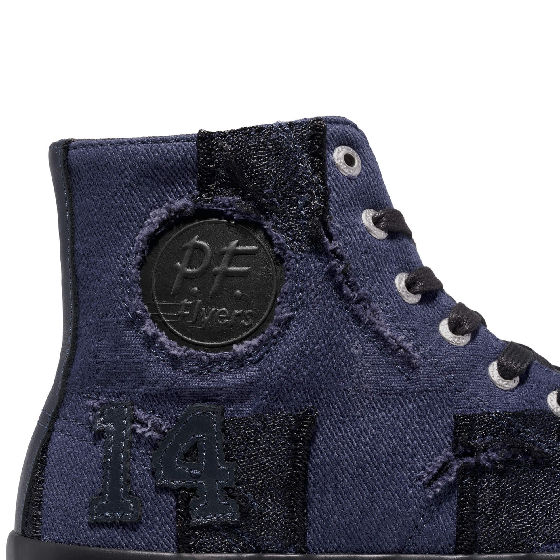 Close-up of a blue high-top sneaker with 'P.F. Flyers' branding on a white background