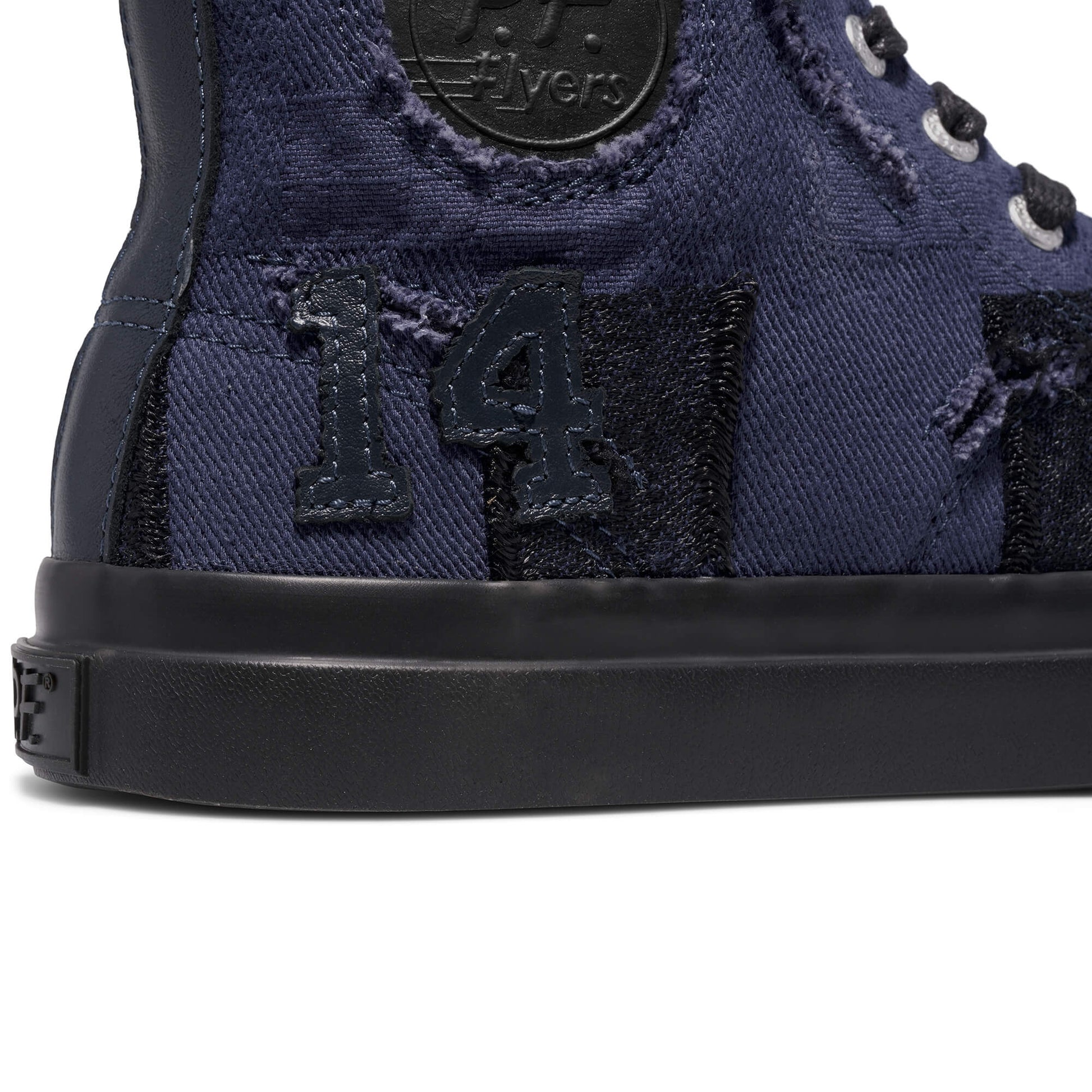 Close-up of a navy blue high-top sneaker with the number 14 on a white background