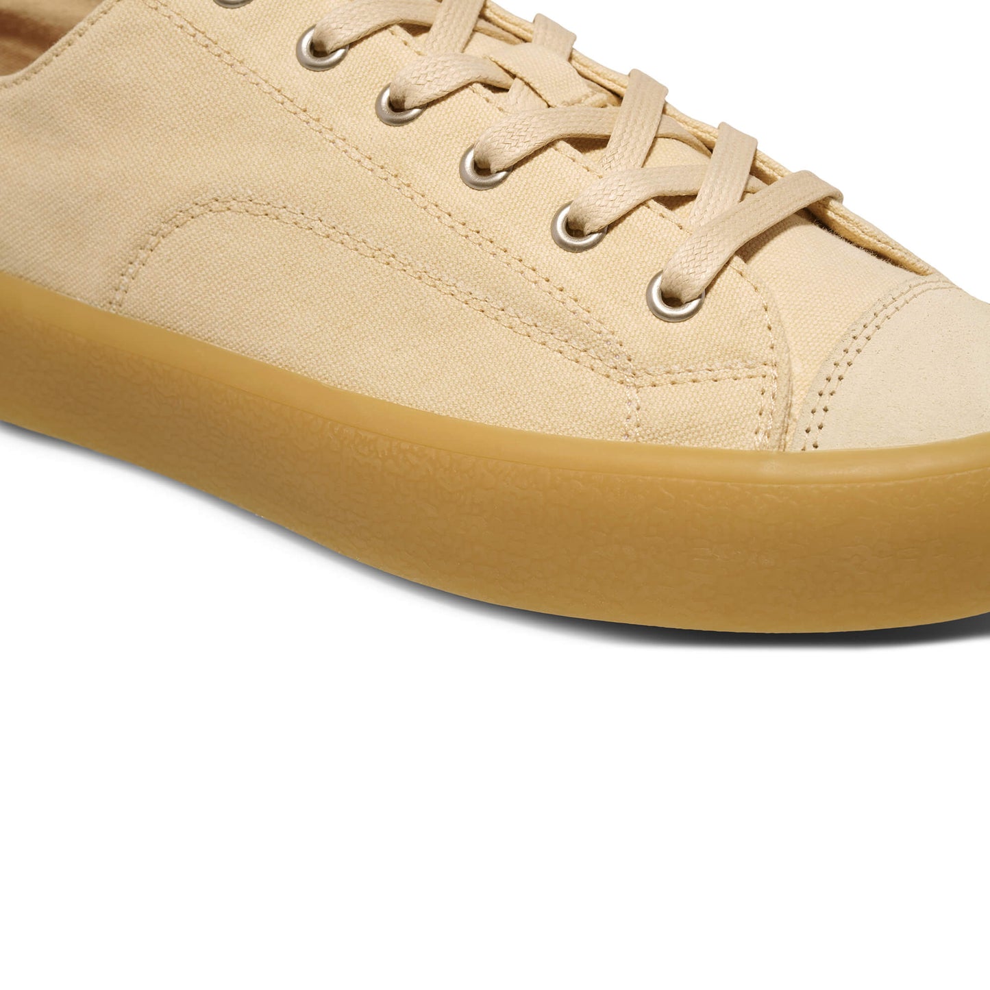 Close-up of a beige sneaker with a tan sole on a white background.