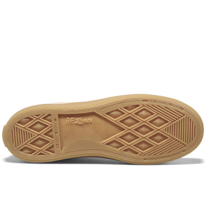 Close-up of a tan shoe sole on a white background.