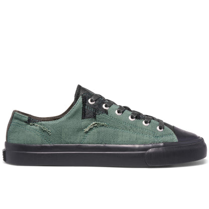 Green sneaker with black accents on a white background
