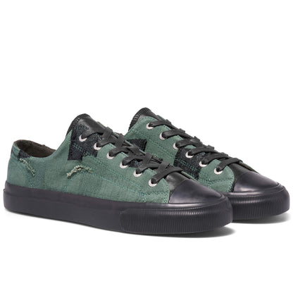 Green sneakers with black soles on a white background