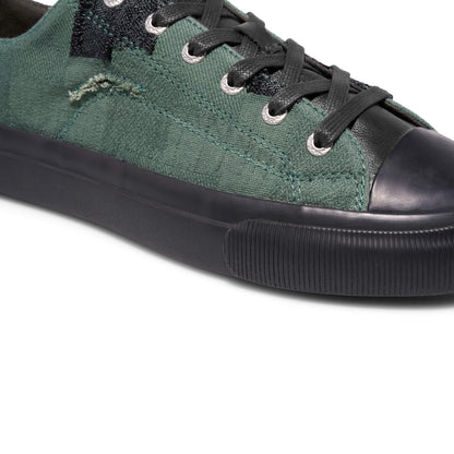 Green sneaker with black accents on a white background