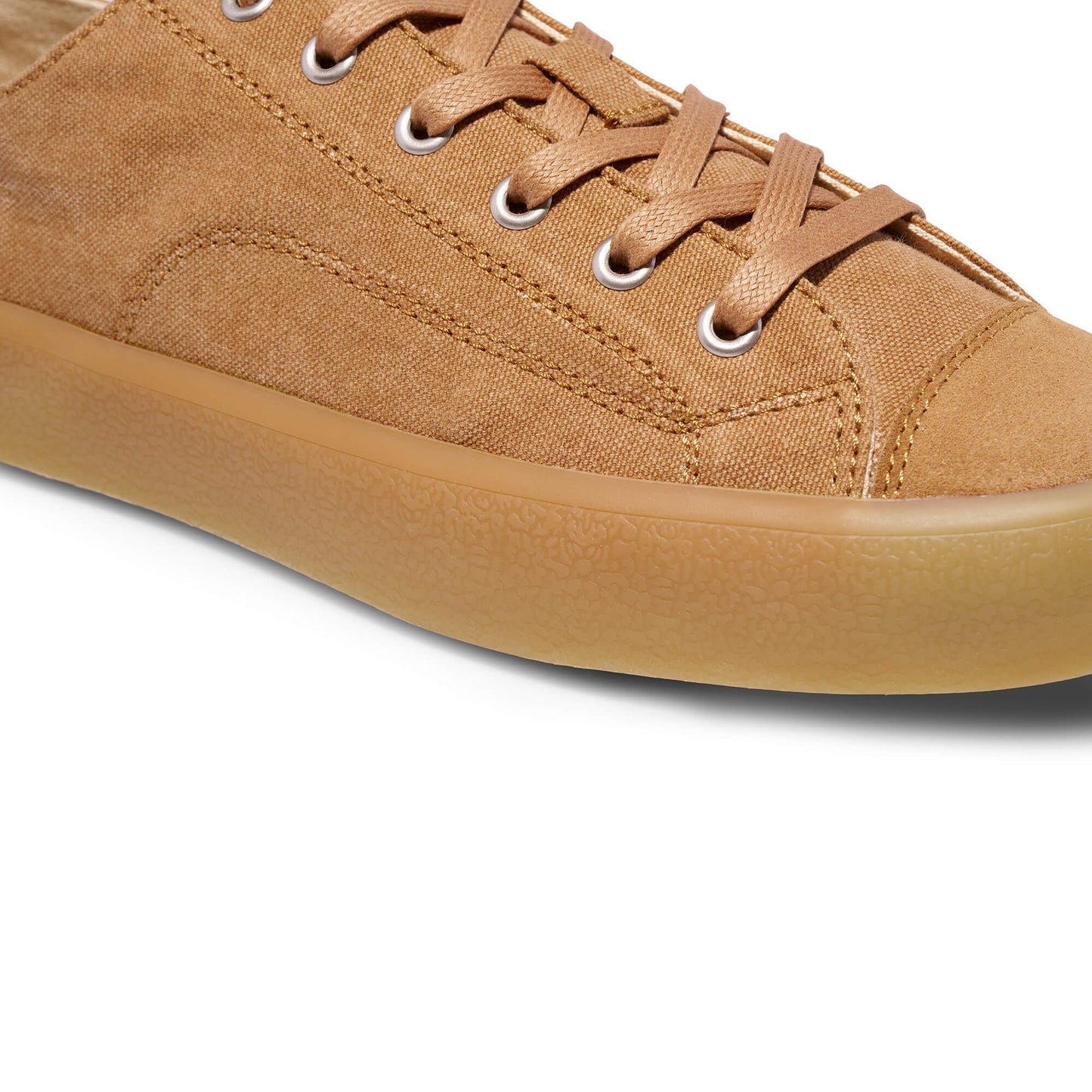 Close-up of a tan sneaker with a white background.