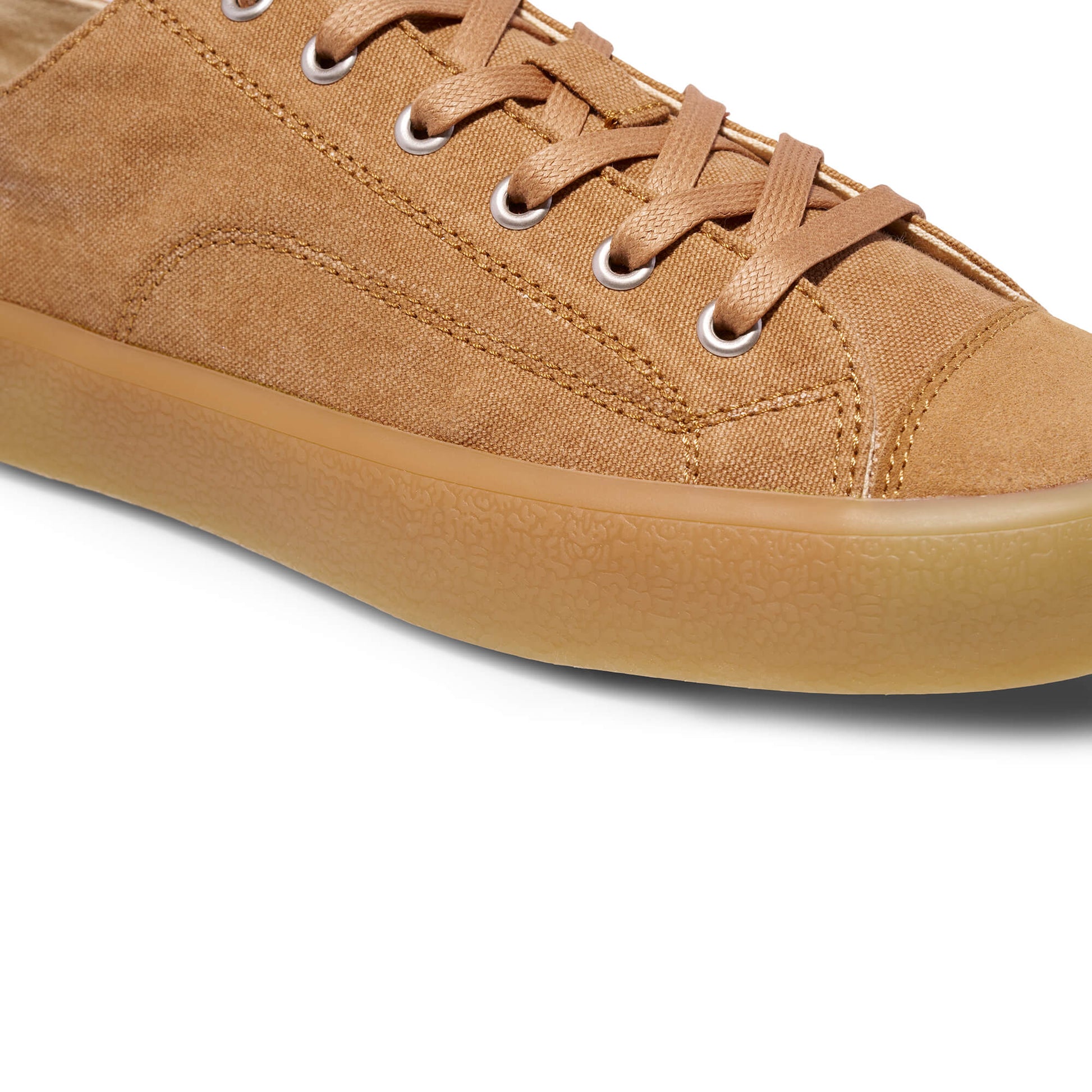 Close-up of a tan sneaker with a white background.
