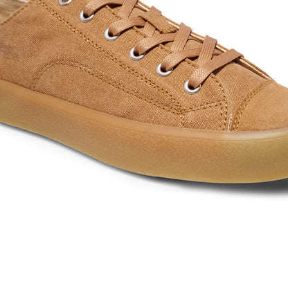 Close-up of a tan sneaker with a white background.
