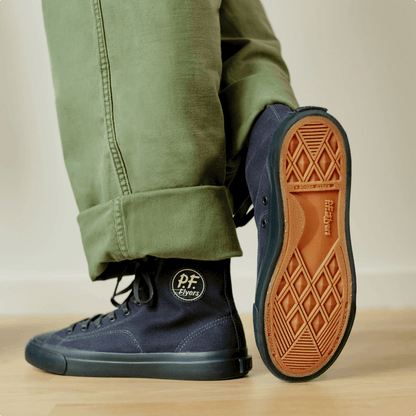 Navy high-top sneakers on a wooden floor. 