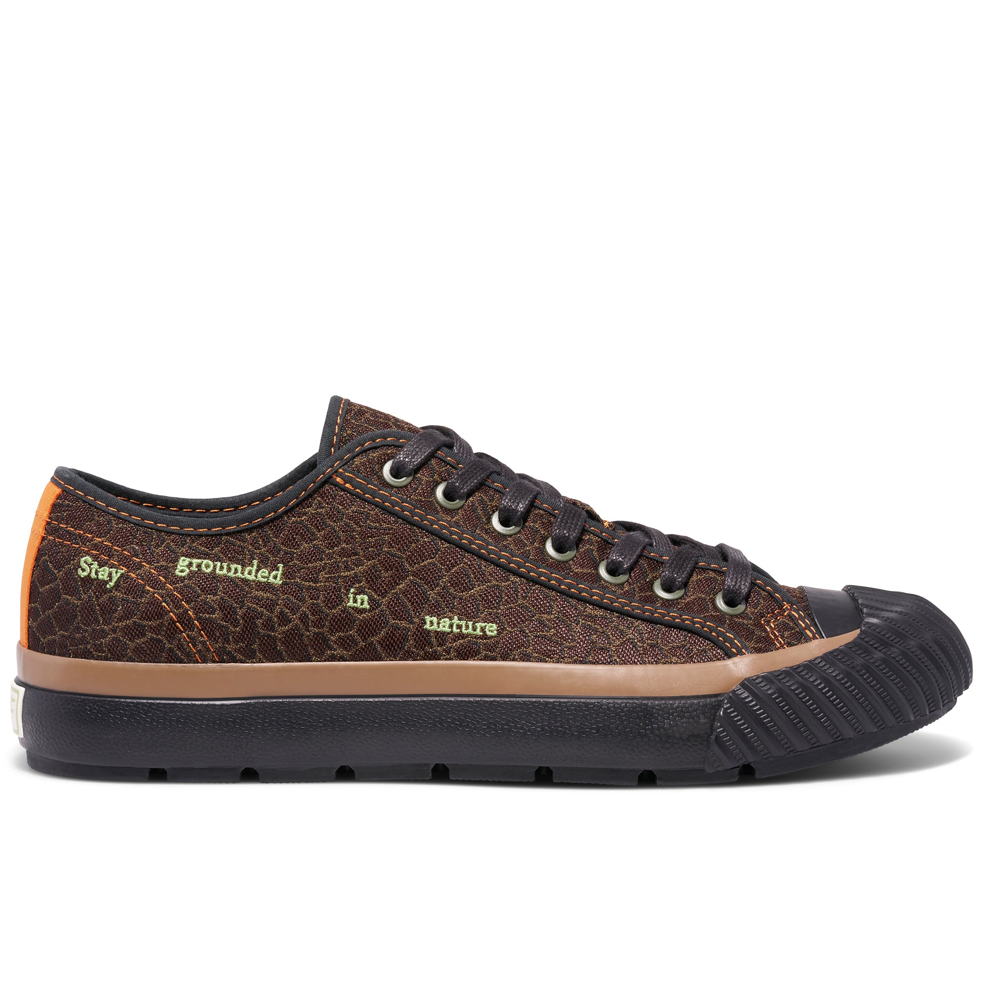 Brown low-top sneaker on a white background, with “Stay grounded in nature” embroidered on the upper.