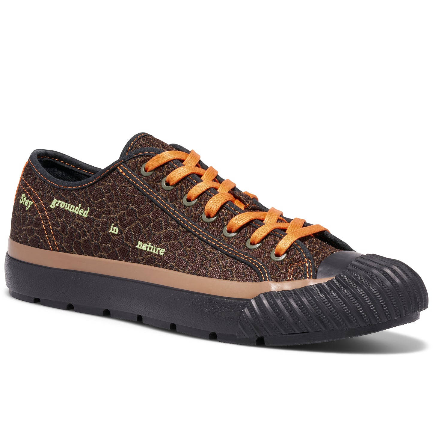Brown low-top sneaker with orange laces on a white background, with “Stay grounded in nature” embroidered on the upper.