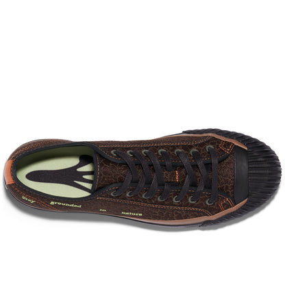 Brown low-top sneaker on a white background, with a frog foot silhouette visible on the insole.