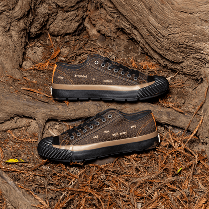 Brown low-top sneakers with black soles on a natural wooden surface.