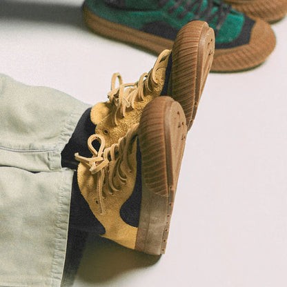 Close-up of a tan sneaker with a white sole on a light gray background