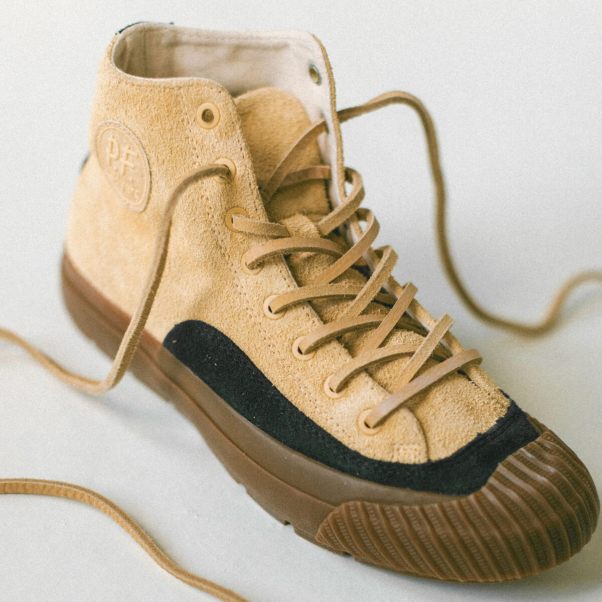Beige high-top sneaker with gum sole on a light background